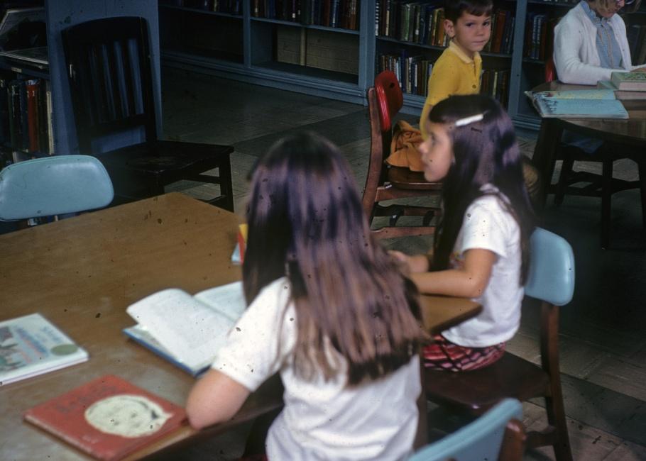 Girls reading at a table in the library